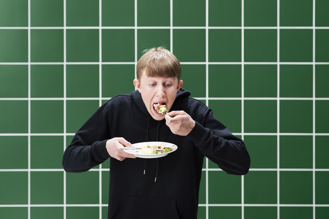 Jeune homme qui dévore un plat IKEA.