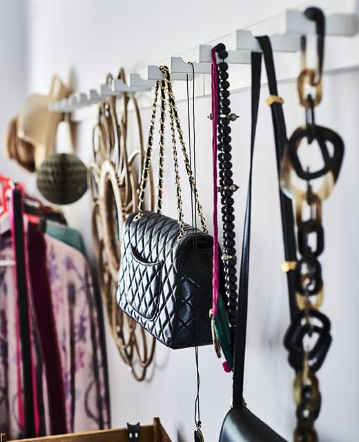 Jewellery and bags hanging on a row of hooks.