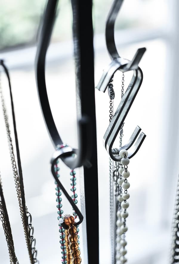 Jewellery hanging from S-hooks.