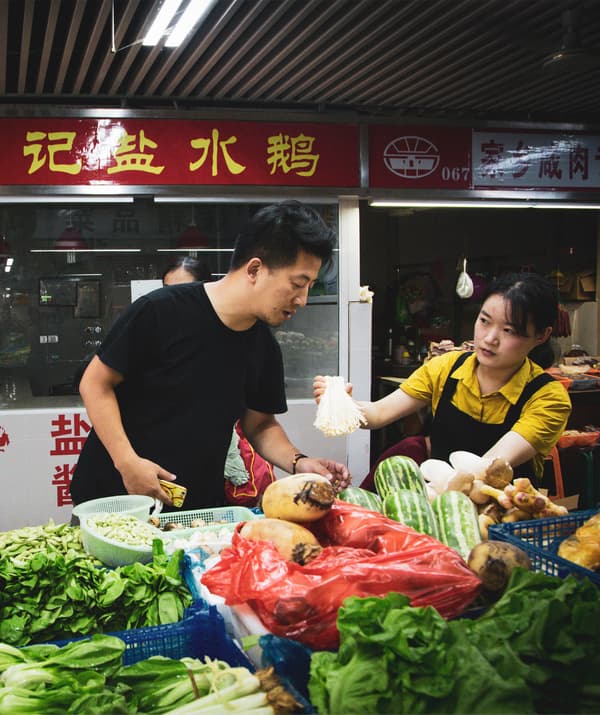 Jiaqin ยืนอยู่ตรงแผงขายผัก