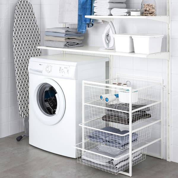 JONAXEL förvaring med lådor och hyllor i ett badrum. Till höger om hyllorna står en tvättmaskin och bredvid den lutar en tvättbräda mot väggen.