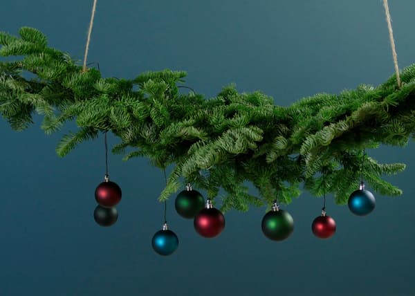 Julgranskulor hänger på en grön krans.