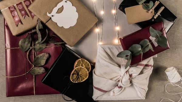 Julklappar liggande i hög på beige linneduk.