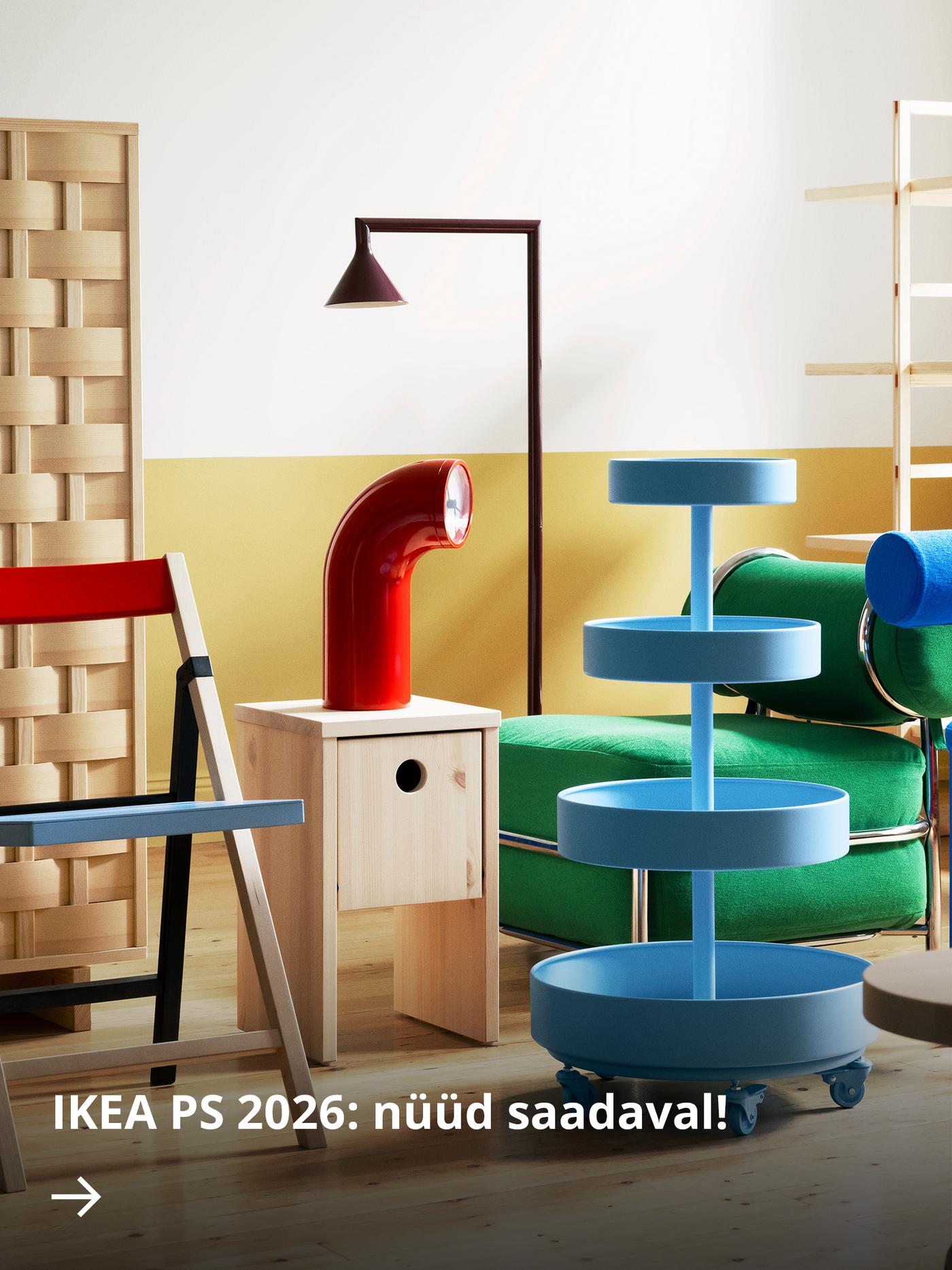 Kaasaegne puhkenurk rohelise IKEA PS 2026 tugitooli, tumepunase abilaua ja raamitud kunstiteosega.