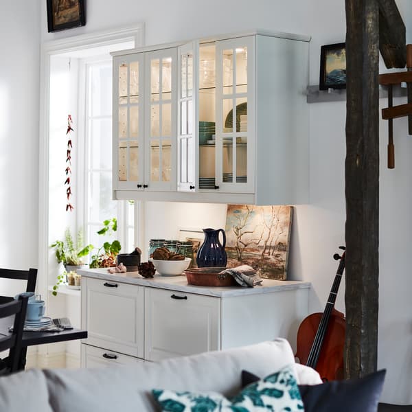 Kabinet dasar BODBYN yang berwarna putih pudar dengan laci dan kabinet dinding berpintu kaca dan pencahayaan mengoptimumkan penggunaan dinding yang sempit.