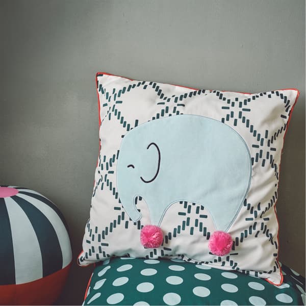 KÄPPHÄST cushion showing a green elephant with pink pompom feet against a dark green and white pattern.