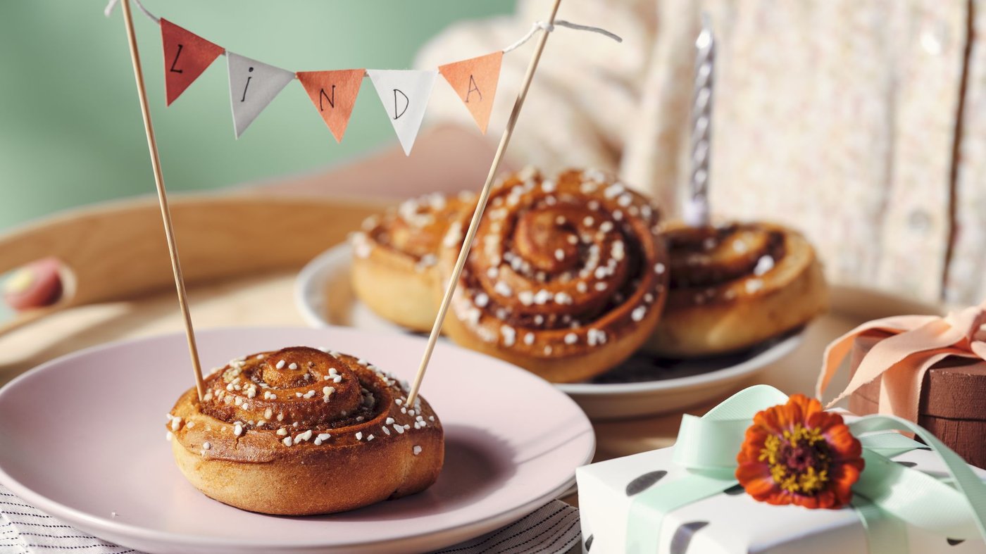 KAFFEREP cinnamon bun on plate with birthday banner
