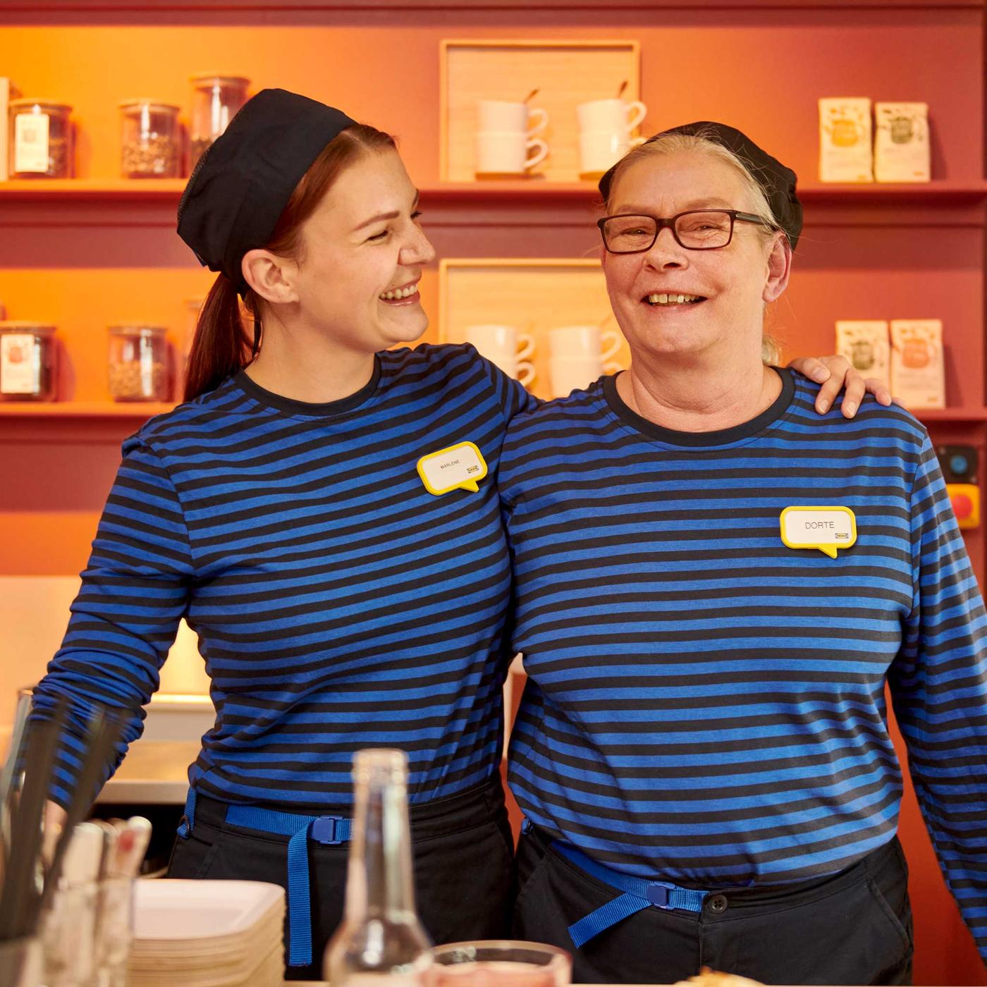 Kaksi IKEA-työntekijää hymyilee sinisissä paidoissa.