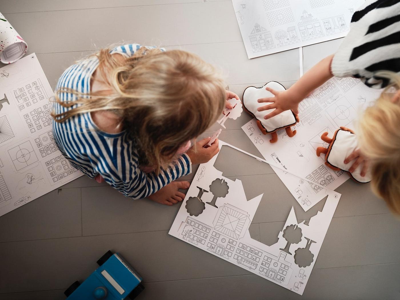 Kaksi lasta leikkimässä lattialla