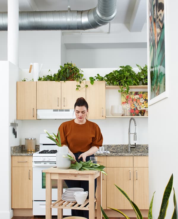 Kara dispone i fiori in un vaso su un carrello di legno in cucina - IKEA