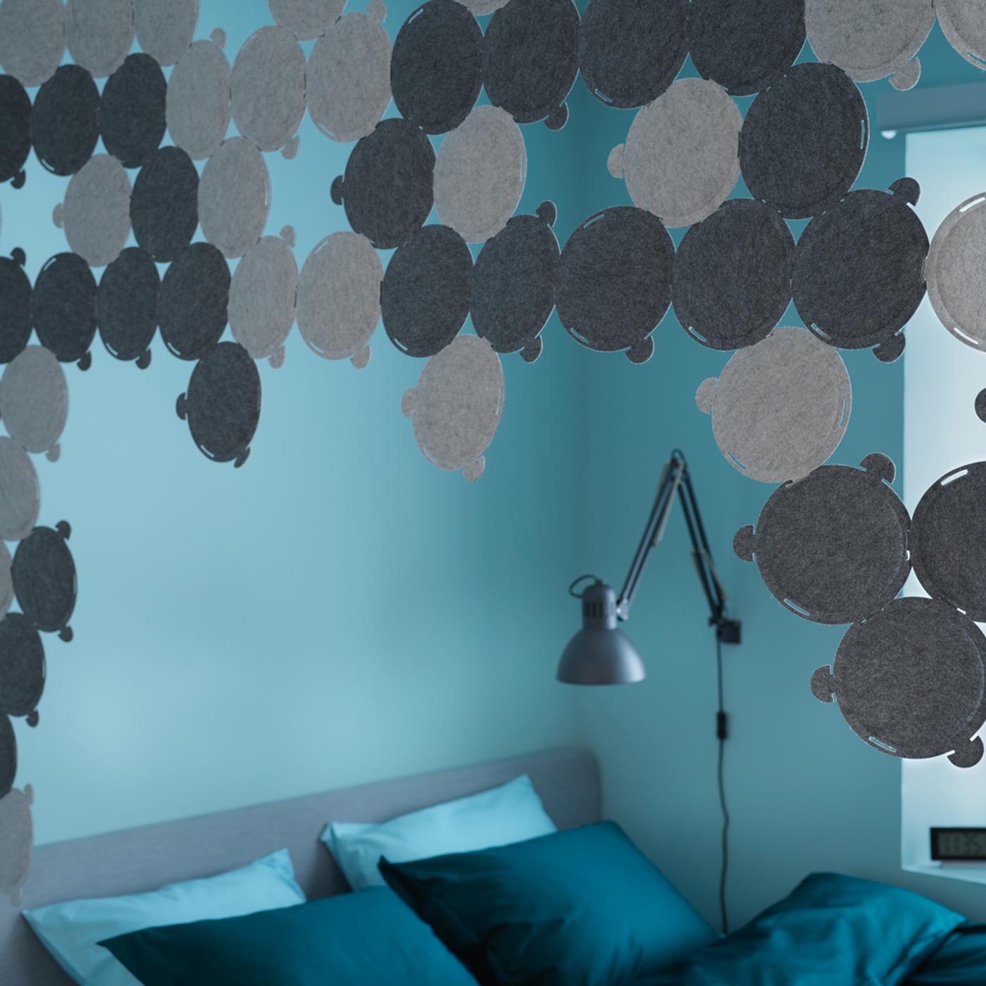 Katil SLATTUM terletak dekat dengan tingkap di dalam bilik tidur. Di atas katil terdapat kanopi yang dibuat daripada panel penyerap bunyi ODDLAUG.