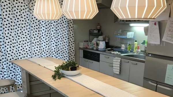 カウンターの奥にキッチンスペースがあり、ドット柄のカーテンが掛けられている。