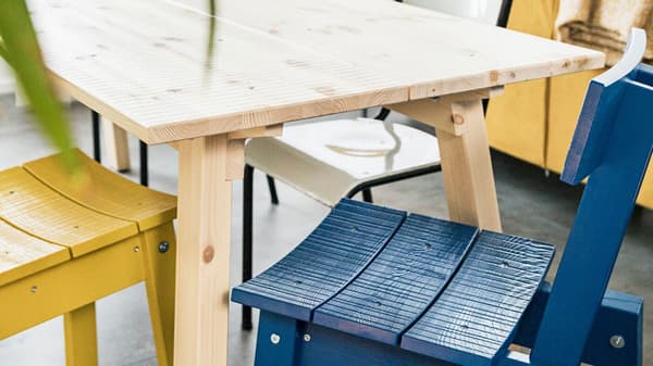 Két IKEA INDUSTRIELL fa szék, egy sárga és egy kék, tömör fenyőből.