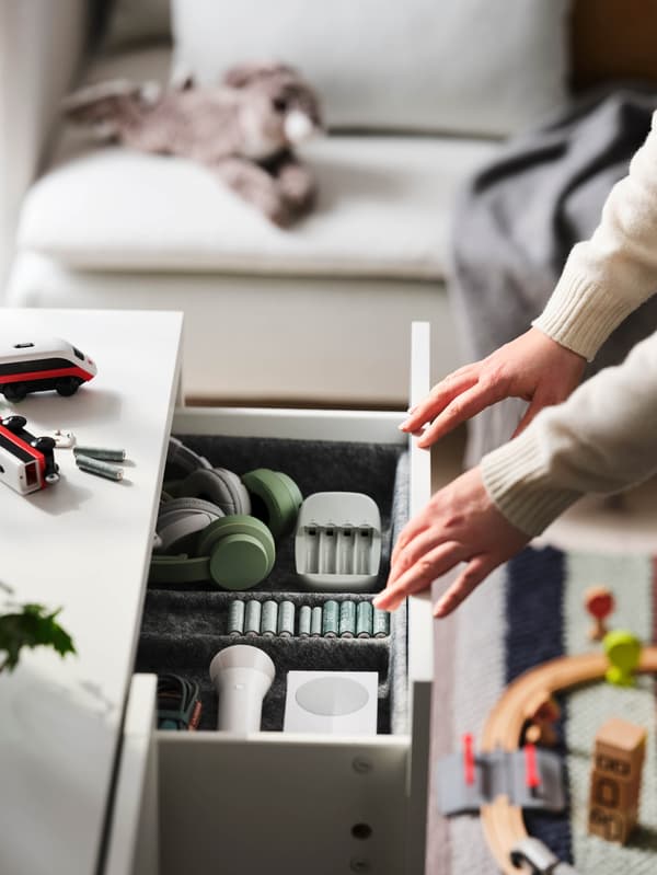 Két kezet látunk, amint éppen kihúzza a fiókot. A fiókban fülhallgatók, LADDA tölthető elemek és egy STENKOL elemtöltő kapott helyet.