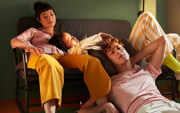 Két tanuló pihen egy kanapén, a harmadik pedig a padlón.