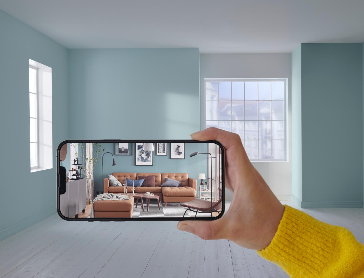 Kezében telefon az IKEA alkalmazással.