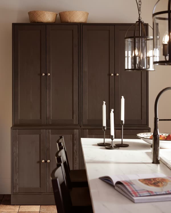 خزائن قاعدة وخزائن قابلة للتكديس بني داكن توفر تشكيلة تخزين كبيرة. سطح عمل شكل رخامي في المقدمة.