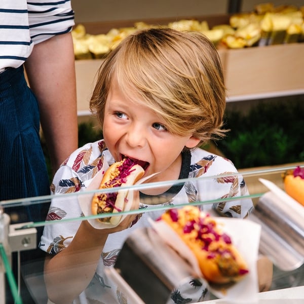 Kid is eating hot dog