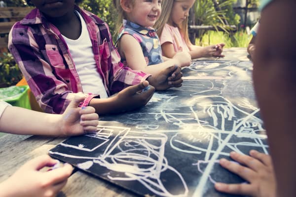 Kids drawing on a black slate