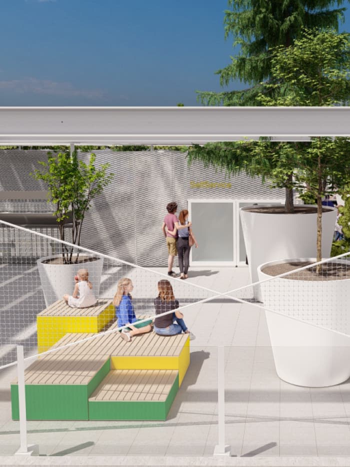 Kinder sitzen auf bunten Sitzstufen auf der Dachterrasse; im Hintergrund große Pflanzgefäße und ein moderner Außenbereich.