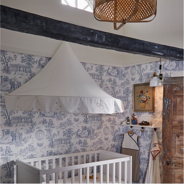 Kinderzimmer mit einem weissen Babybett und einer RÖDHAKE Hängedeko/Schwebeschirm