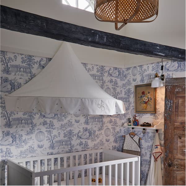 Kinderzimmer mit einem weißen Babybett und einer RÖDHAKE Hängedeko/Schwebeschirm