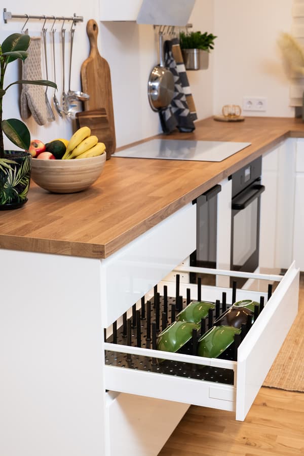 Kitchen drawer with internal organisers; wooden worktop and white cabinets in the background.