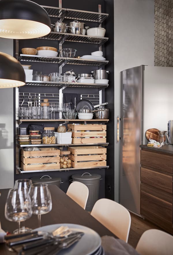 Kitchen shelf in a pad comprising metal shelves and wooden boxes.