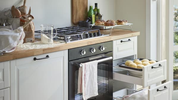 Kitchen with an oven and stovetop with open drawers on the side