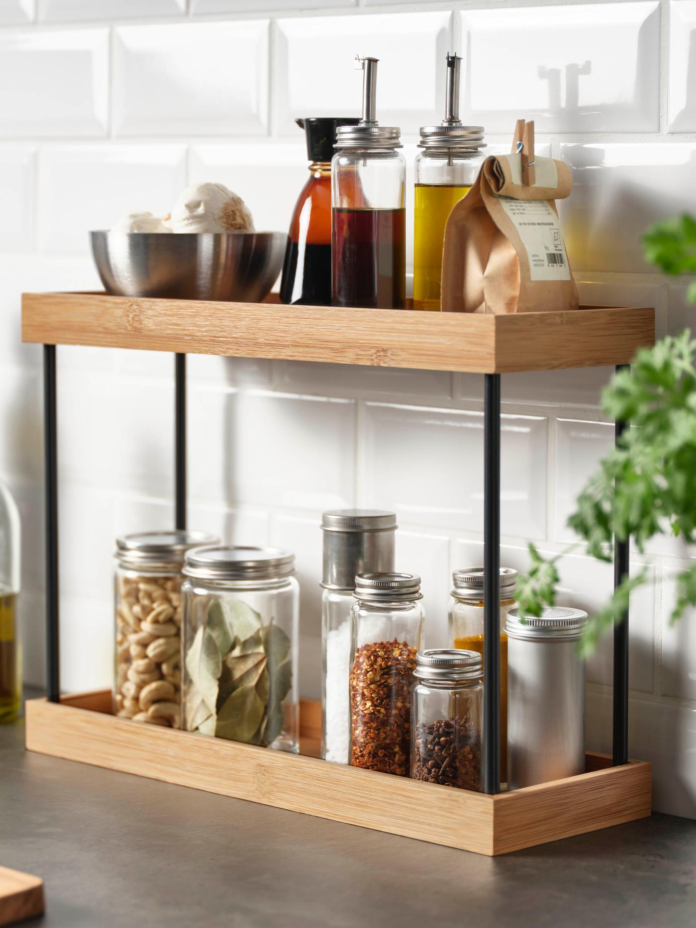 Kitchen worktop storage shelves filled with oils and spices in glass jars