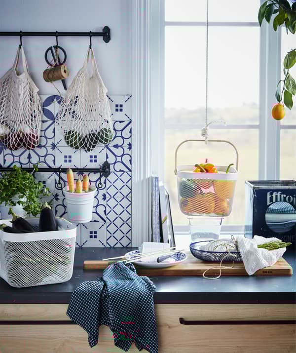 Kitchen worktop with various produce kept in hanging and standing containers (same image as the one above).