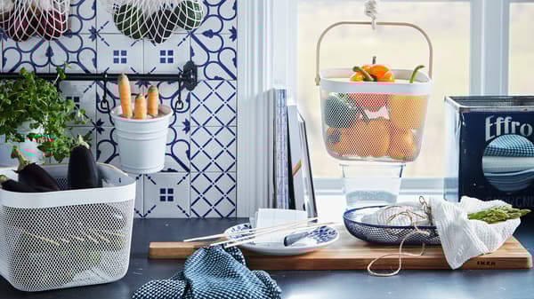 Kitchen worktop with various produce kept in hanging and standing baskets, like KUNGSFORS nets and RISATORP baskets.