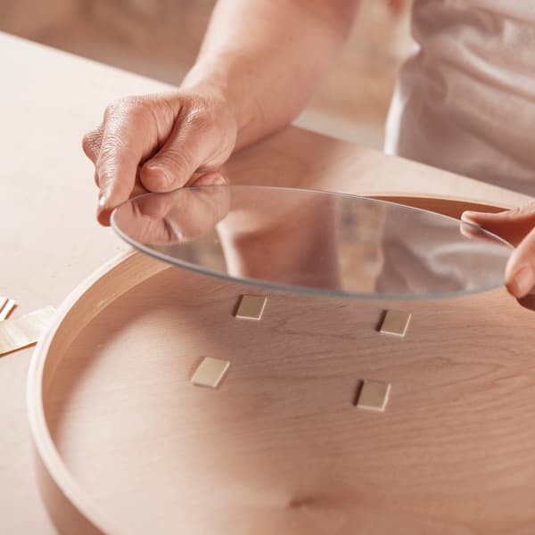 Kleef een ronde spiegel op een houten dienblad.