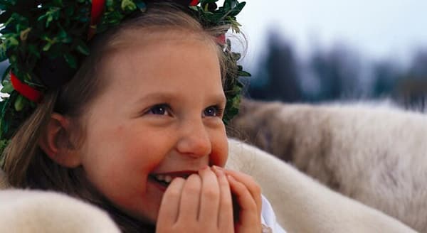 Kleines Mädchen mit Blumenkranz auf dem Kopf und im weißen Gewand als Lucia