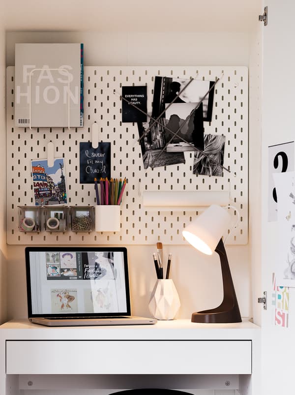 KLEPPSTAD wardrobe fashioned to be a very compact workspace, with a SKÅDIS pegboard holding accessories, and a SVALLET lamp.