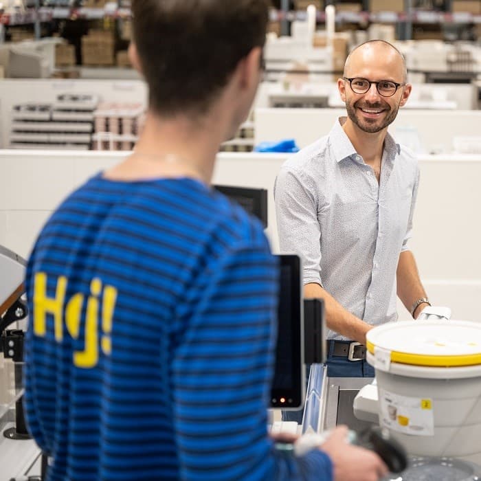 Klientas perka produktus ir kalbasi su IKEA darbuotoju.