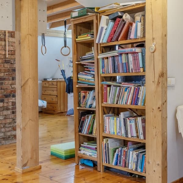 Книжный шкаф с детскими книгами в уютном деревянном интерьере