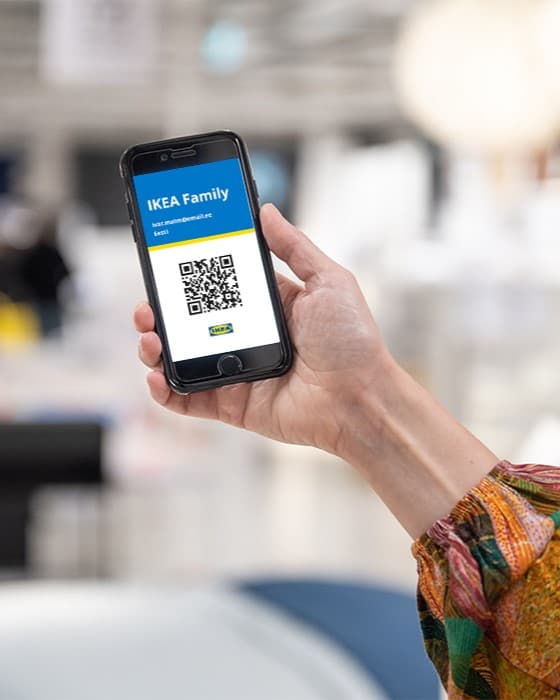 kobieca ręka trzyma telefon na którym jest kod QR z kartą ikea family