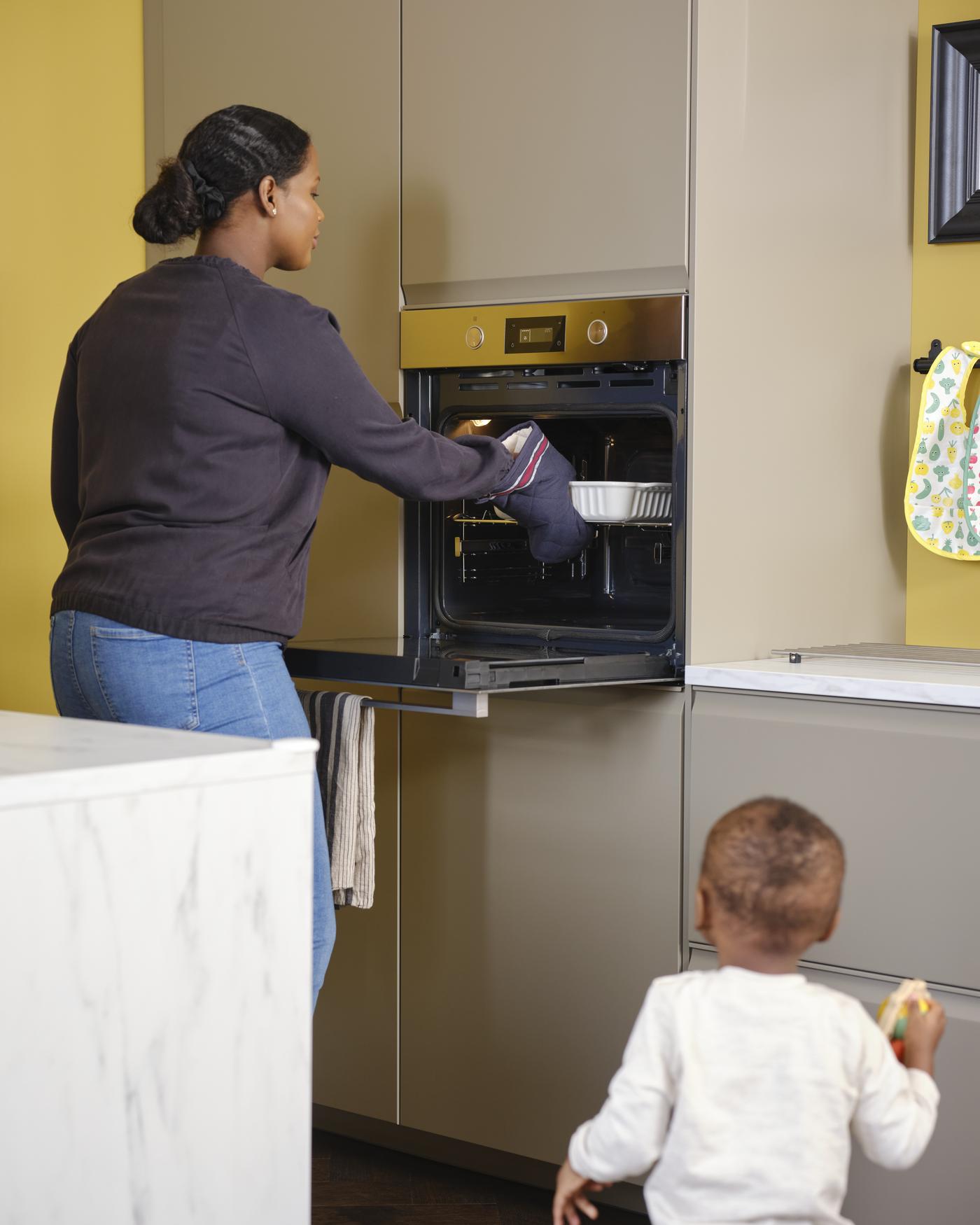 Kobieta i dziecko stoją w kuchni.