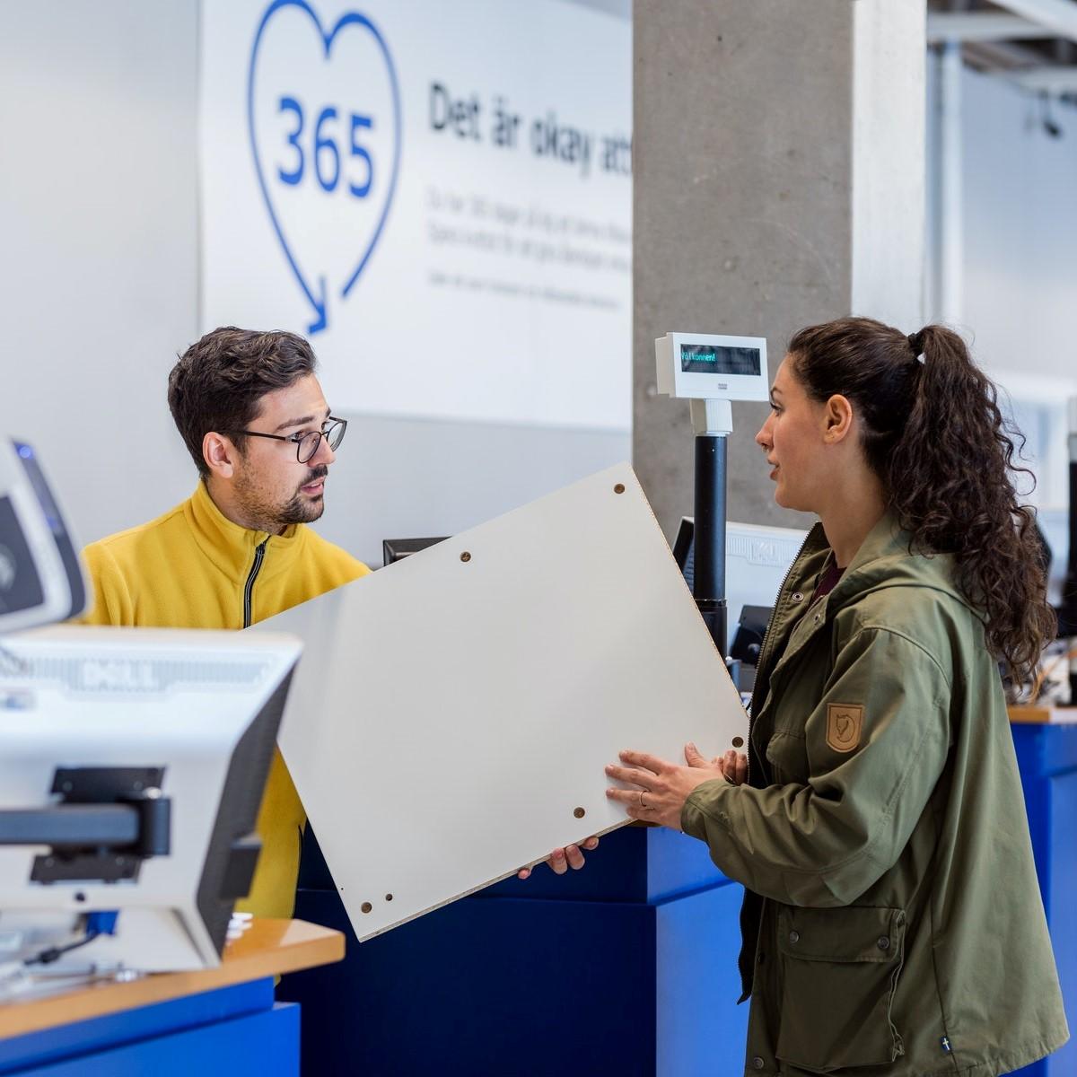 Kobieta robiąca zwrot w sklepie IKEA. Pracownik IKEA przyjmuje zwrot.