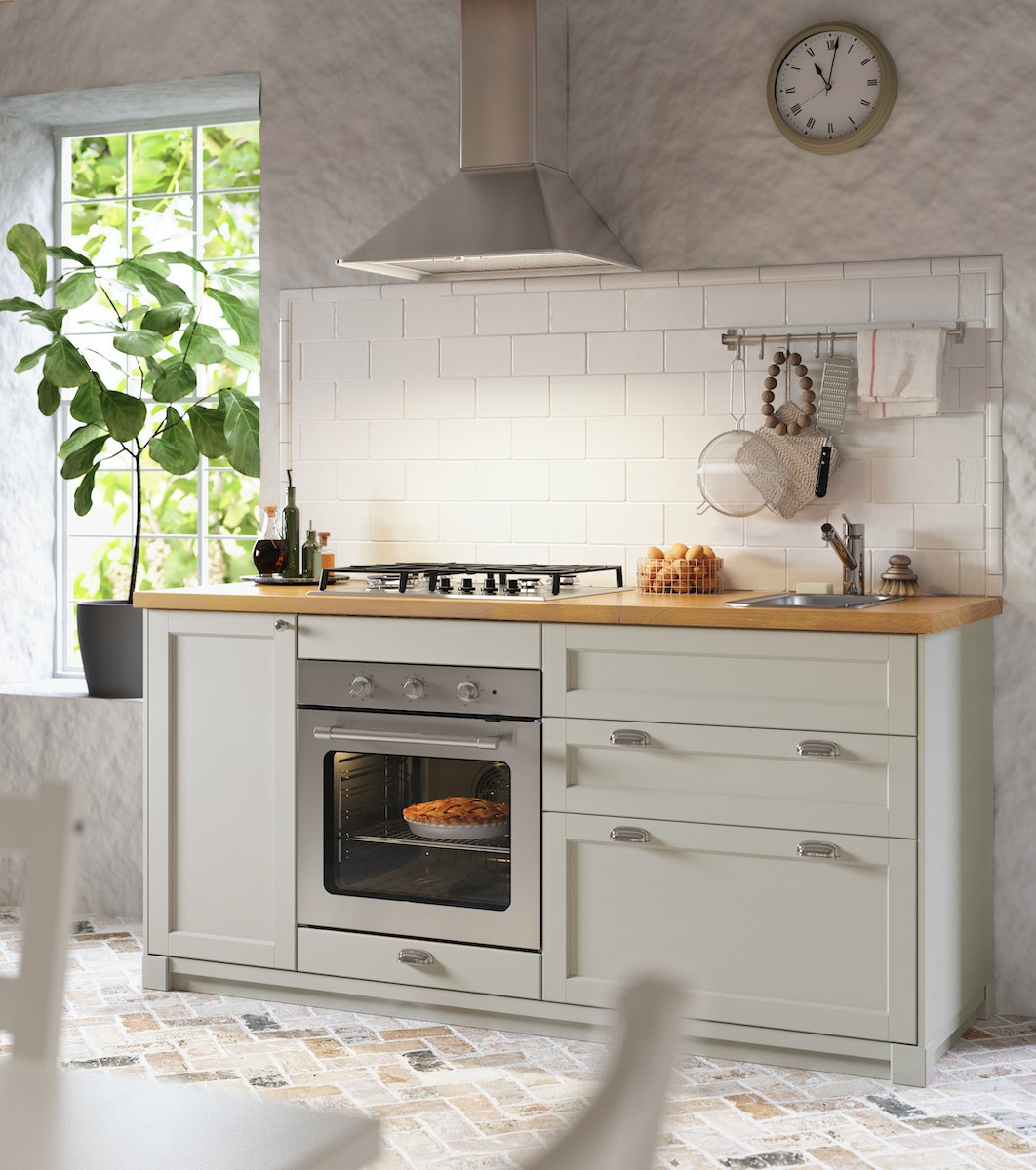 Køkken med lysegrå låger i shakerstil og moderne hvidevarer.