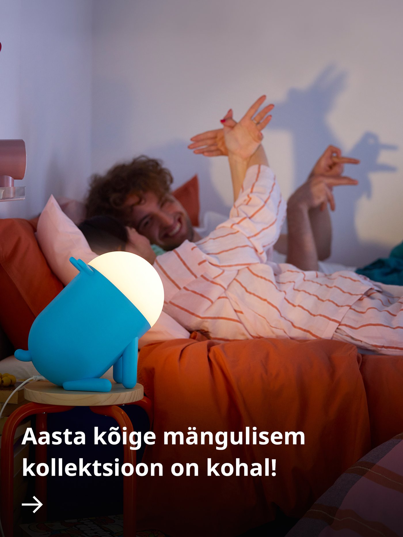 Kollane kaelkirjakukujuline GREJSIMOJS põrandalamp seisab pimedas toas lapse voodi kõrval.