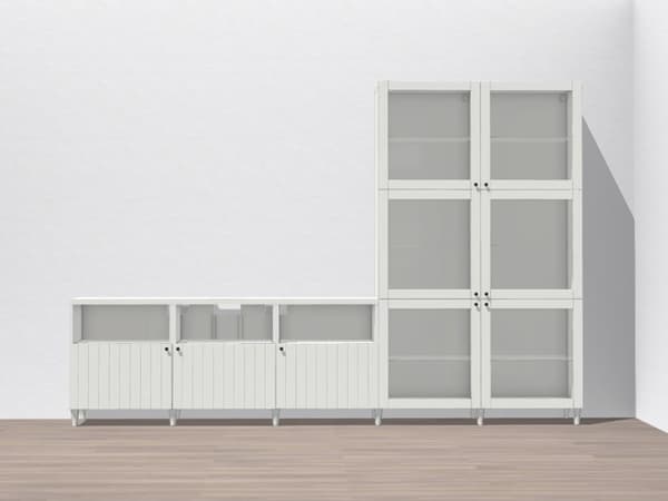 Kombination aus niedrigen und hohen Vitrinen mit Glastüren. Die Möbel sind in einem hellgrauen oder weißen Farbton gehalten und bieten viel Stauraum durch geschlossene sowie verglaste Fächer.