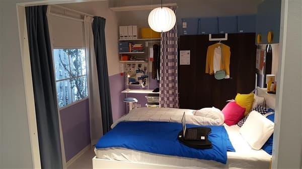 Kompaktes IKEA Schlafzimmer mit weißem Bett, knallblauer Decke und funktionaler Aufbewahrung – perfekte Lösungen für kleine Räume und moderne Einrichtungsideen von IKEA.

