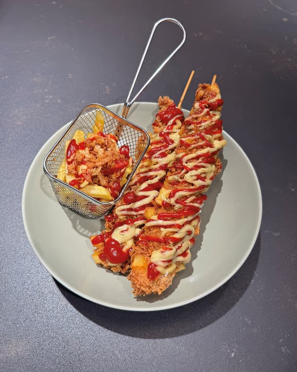KOREAN CORN DOGS mit Gochujang-Ketchup & Sas Senap Kewpie Mayo auf einem Teller präsentiert.