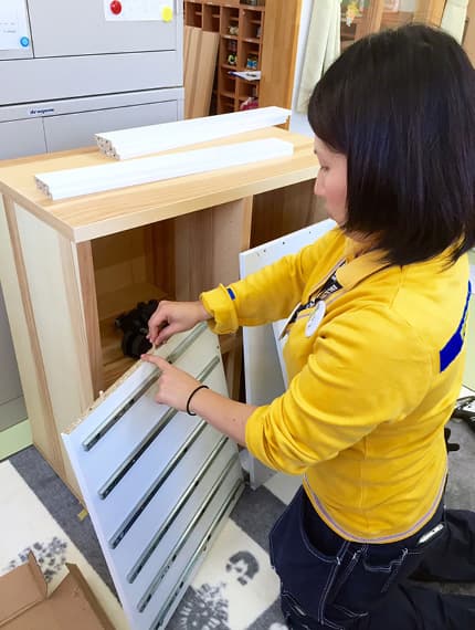 コワーカーが家具を組み立て中。