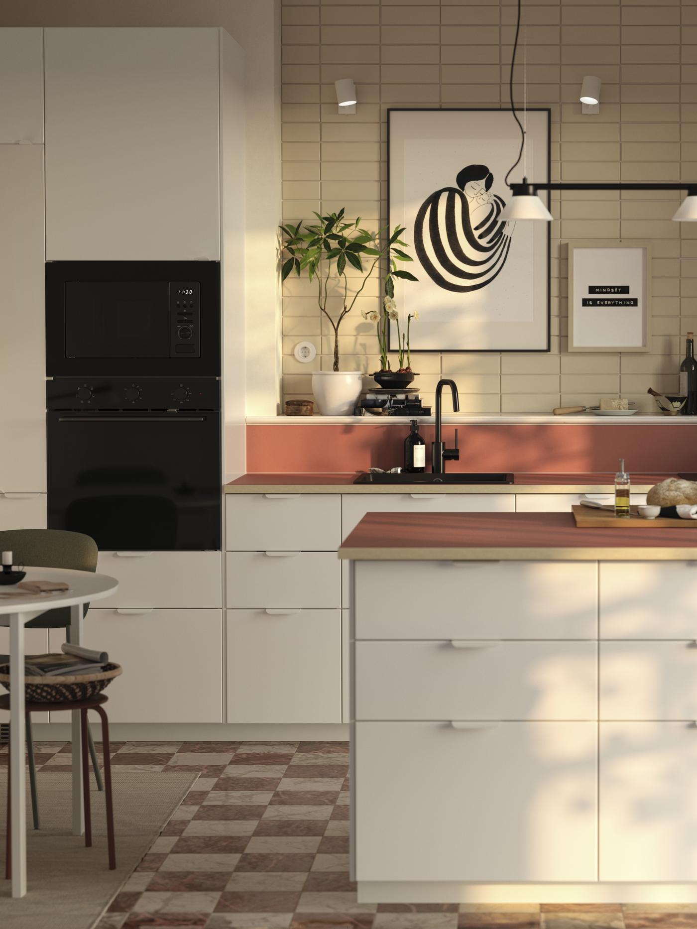 Kuchnia METOD z białymi frontami VEDDINGE, czerwonym blatem i czarnym AGD w zabudowie. 