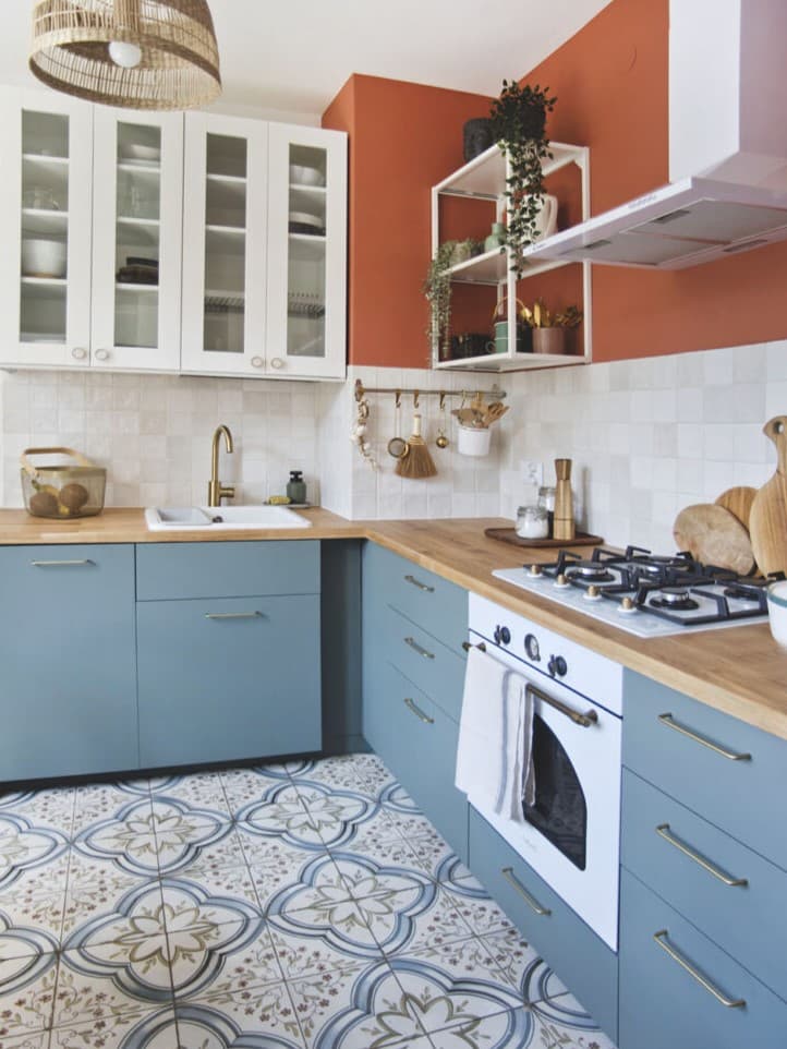 Kuchnia z szarozielonymi frontami i drewnianym blatem.