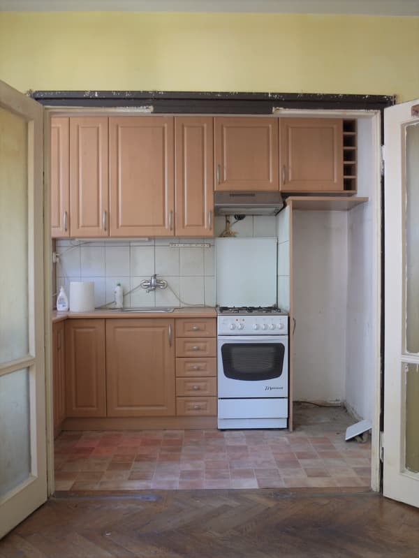 Kuchnia ze starymi, bukowymi szafkami przed metamorfozą.