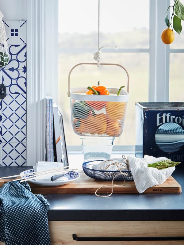 Kuchynská pracovná doska s potravinami zavesenými v  koši RISATORP.